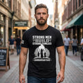 Man wearing a black t-shirt with 'Strong Men Build Strong Families' text and graphic on a city street.